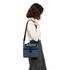 A cooler bag in navy blue, featuring a shoulder strap and zippered compartments. It has a logo on the front.