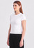 A fitted white women's baby tee displayed on a model, paired with black bottoms, featuring a subtle logo.