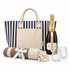 A striped tote bag, a bottle of Chandon Brut, two glasses, and a rolled blanket with a ribbon.