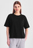 A black box tee in a relaxed fit, featuring short sleeves. The model wears it with grey bottoms.