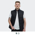 A man wearing a black puffer vest over a white t-shirt, standing against a plain background. The vest features a logo.