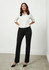 A pair of women's black slacks featuring a tailored fit, styled with a white shirt and heels, standing on a concrete floor.