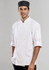 A white long sleeve chef jacket with a button-up front, worn by a man, paired with a black chef hat.
