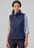 A women's softshell vest in navy blue, featuring a zip front and a collar, paired with a light long-sleeve top.