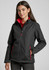 A fitted black jacket with red accents, featuring zippered pockets and a high collar, modelled by a young woman.