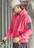 A pink unisex water-resistant hoodie with a pocket, worn by a person in a hard hat and gloves, in a construction setting.
