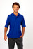 A model wearing a blue regular pique knit polo shirt, paired with grey pants. The shirt features a collar and short sleeves.