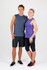 A man in a blue sleeveless tee and shorts stands next to a woman in a purple sleeveless top and black leggings.