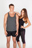 A grey T-back singlet worn by a male model, paired with a female model in a black top and leggings.