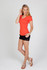 A woman wearing an orange marl V-neck T-shirt paired with black shorts and sandals, posing against a plain background.
