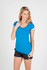 A blue women's scoop neck t-shirt displayed on a model, paired with black shorts. The t-shirt has a logo.