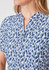 A close-up of a women's tunic featuring a blue and white stardust print, with a notch collar and buttons.