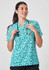 A turquoise tunic with a stardust print, featuring a collar and short sleeves, worn by a smiling woman holding a stethoscope.
