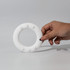 A hand holding a white silicone wrist disc with textured buttons, designed for promotional use.