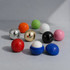 A collection of colourful lip balm balls in red, blue, black, pink, green, white, gold, and silver, featuring various finishes and shapes.