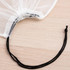 A white nylon mesh produce bag with a gathered top and a black drawstring for closure.