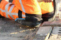 UltraKnee ULTRAKNEE Hammock 2 Professional External Work Trade Protector - Set, close-up view of a worker wearing knee protection while kneeling on the ground during construction work.