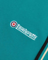 Lambretta Mens Casual Classic Twin Tipped MOD SKA Polo Shirt, close-up of the turquoise fabric with embroidered Lambretta logo and target emblem.
