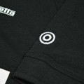 Lambretta Mens Classic Retro 2 Tone Mod Ska Casual Polo Shirt, close-up of black fabric with embroidered target logo detail.