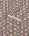 Lambretta Mens Geometric Target Retro Mod Ska Casual Polo Shirt, close-up of the shirt's fabric featuring a repeating geometric target pattern in beige and navy colors.