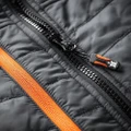 Scruffs Mens Trade Padded Lightweight Work Gilet Body Warmer, close-up of black padded fabric with black zipper and orange trim detail.