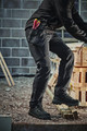 Scruffs Tech Holster Mens Multi Pocket Workwear Trousers, close-up of a worker wearing black tactical work trousers with a holster attached to the side, carrying tools on a construction site.