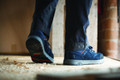 Scruffs Halo 3 Mens Safety S3 Lace Up Steel Toe Midsole Trainers, blue safety shoes worn by a person standing on a wooden floor with dried leaves.