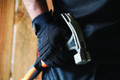 Scruffs Trade Work Men's Padded Palm Gloves, close-up of black glove with padded palm, held by a person in work attire