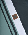 Lambretta Mens Vintage Classic Mod Ska Casual Smart Polo, close-up image showing striped fabric details and a round brown leather logo patch.