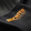 Scruffs Pro Base Layer Bottoms, close-up of black fabric with orange and gray logo text.