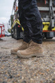 Apache APACHE Outback Mens Side Zip Safety Work Composite Toe S3 Boots, beige safety boots worn by a person standing outdoors on gravel.