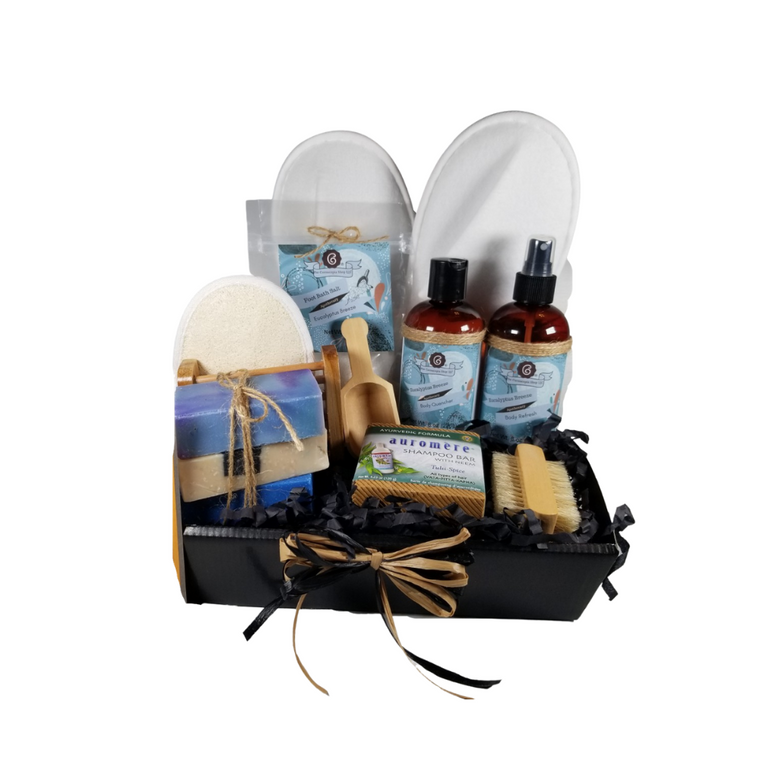 Men’s Eucalyptus Breeze Spa - Gift Basket Tray by The Cornucopia Shop LLC:  a luxury spa gift just for him.  Our line includes Hand Crafted Cold Process Soaps in complimentary scents, Body Quenchers to soften skin, and Body Refresher Sprays, to use anytime for a cooling mist with a light scent he'll love. 8 ounces of foot soak to ease, sooth and refresh tired feet. Can also be used in the tub for overall body rejuvenation.  This gift also includes a natural fiber nail brush, a bamboo and wood soap saver tray, and wood scoop for the perfect measure of foot soak. A one size fits most spa slipper he can slip into after enjoying his soak.      Includes:  •	1- 8 oz Eucalyptus Breeze Foot Soak, no dyes,  •	1- 8 oz Eucalyptus Breeze Body Quencher Lotion •	1- 8 oz Eucalyptus Breeze Body Refresh Spray •	1- Wooden Bath Salt Scoop  •	1- Natural double bristle sided Nail Brush by Ecolather •	1- Natural Soap Saver Bamboo and Wood Tray by Ecolather •	1- Loofah & Terry Cloth reversible Wash Pad with Wrist Band •	1- Spa Slipper, White, one sizes fits most` •	1- Shampoo Bar with Neem, Ayurvedic formula by Auromere (Vata-Pitta-Kapha) •	3 Cold Process Bar Soaps, o	Bondi Breeze (Light citrus mixed with hints of jasmine, rose and hyacinth with musky base.) o	Dead Sea Mud (Musky earthy fragrance with amber and green base notes. Contains activated charcoal, sea salt, and various clays as exfoliants.) o	Cool Spring Scrub (Fresh clean manly fragrance. Comparable to Irish Spring or another men’s type bar soap. Contains sea salt as an exfoliant.) Gift comes shrink wrapped in reusable gift storage tray paper shred fill, hand tied bow, and enclosure gift card with your personal message. Key Ingredients: Foot Soak: Foot Soak: Epsom Salts, Pink Himalayan Salt, Dead Sea Salt, Eucalyptus Essential Oil, Spearmint Essential Oil, Benzyl Benzoate, Benzyl Salicylate, Limonene, Linalool. White Tea and Orchid Essential Oil. All-natural no dyes. Body Quencher Lotion: Water, Blend of (Coconut Oil, Hempseed Oil, Sunflower Oil, Vitamin E, Mineral Oil), Propylene Glycol, Stearic Acid, Cetyl Alcohol, Phenoxyethanol, Ethylhexylglycerin, Glyceryl Stearate, Petrolatum, TEA 99%, Proprietary Fragrance and Essential Oil Blend, Dimethicone, Carbopol, Disodium EDTA, Allantoin, Aloe Vera Gel.  Body Refresh Spray: Water, Polysorbate 20, Fragrance, DMDM Hydantoin, Disodium EDTA Cold Process Soaps: Olive Oil, Soybean Oil, Coconut Oil, Corn Oil. Sunflower Oil, Organic Shea Butter, Water. Sodium Hydroxide (Lye), Fragrance INCI: Olea Europaea (Olive) Oil, Glycine Soja (Soybean) Oil, Cocos Nucifera (Coconut) Oil, Zea Mays (Corn) Oil, Helianthus Annuus (Sunflower) Seed Oil, Butyrospermum Parkii (Shea Butter), Aqua, Sodium Hydroxide, Fragrance. May contain charcoal, FD&C color. Please note that due to the handmade nature of this soap, color shades and swirl styles may slightly vary. Each loaf and bar is unique!