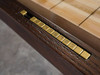 Detail shot of the brass abacus-style scoring system built into the Portland Shuffleboard Table. The distressed wood texture and industrial trim frame the feature, blending functionality with design appeal.