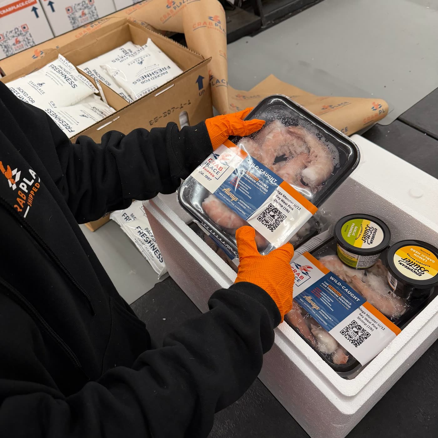 Hands packing wild-caught seafood into an insulated shipping cooler