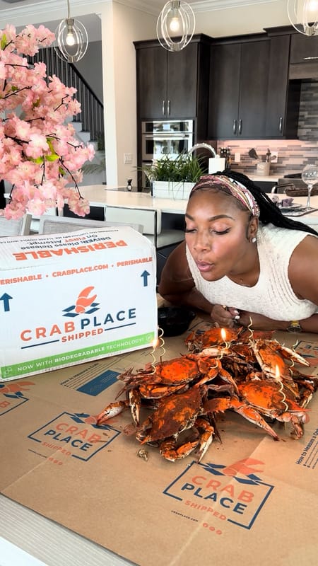 Customer with a pile of steamed crabs and the Crab Place box in her kitchen