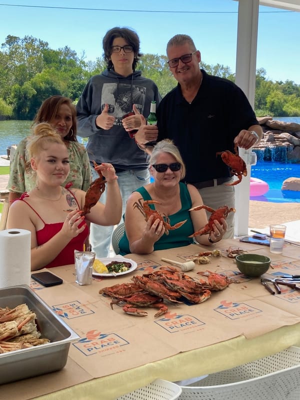 Family cracking steamed crabs poolside