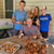 Family of four gathered around pile of steamed Maryland Blue Crabs and Steamed Key West Pink Shrimp
