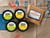 Two Garlic Parmesan Epicurean Butter tubs and two Lemon Garlic Herb tubs beside a bag of Spicy Crab seasoning on a shipping box.