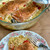 Seasoned Alaskan king salmon fillets baked over creamy orzo with cherry tomatoes, served on a floral plate with a fork.