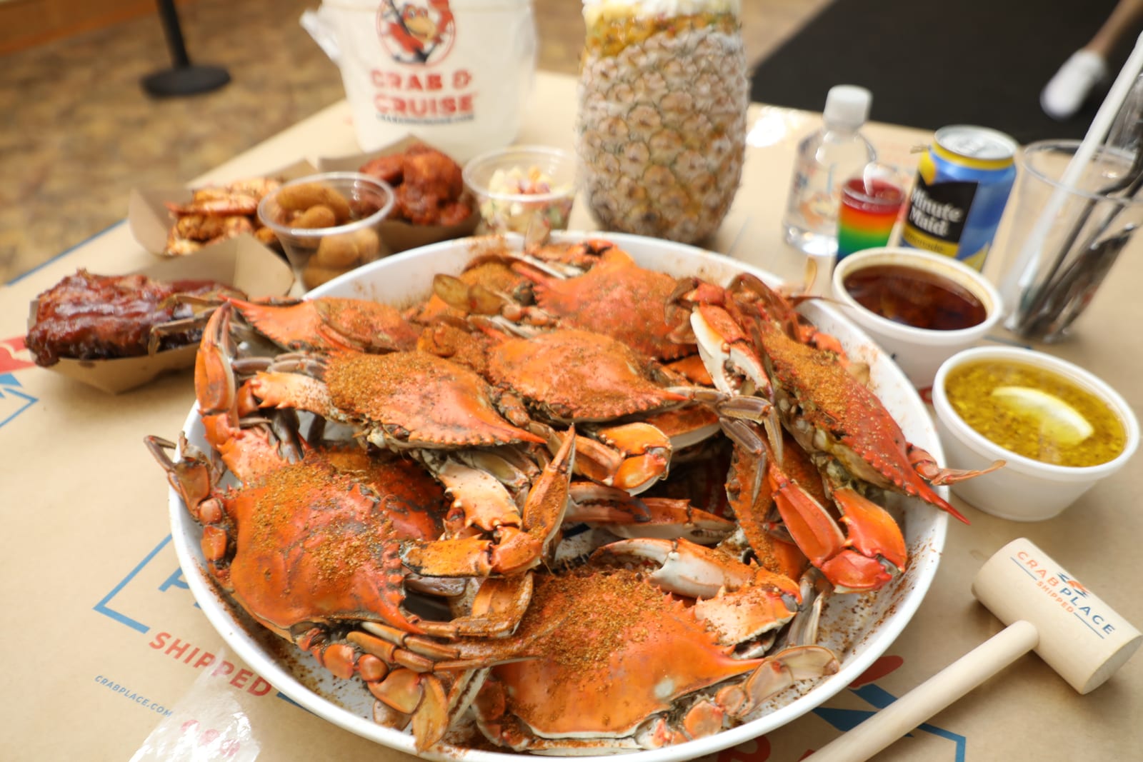 A platter of steamed Maryland blue crabs with sides at a Crab & Cruise event