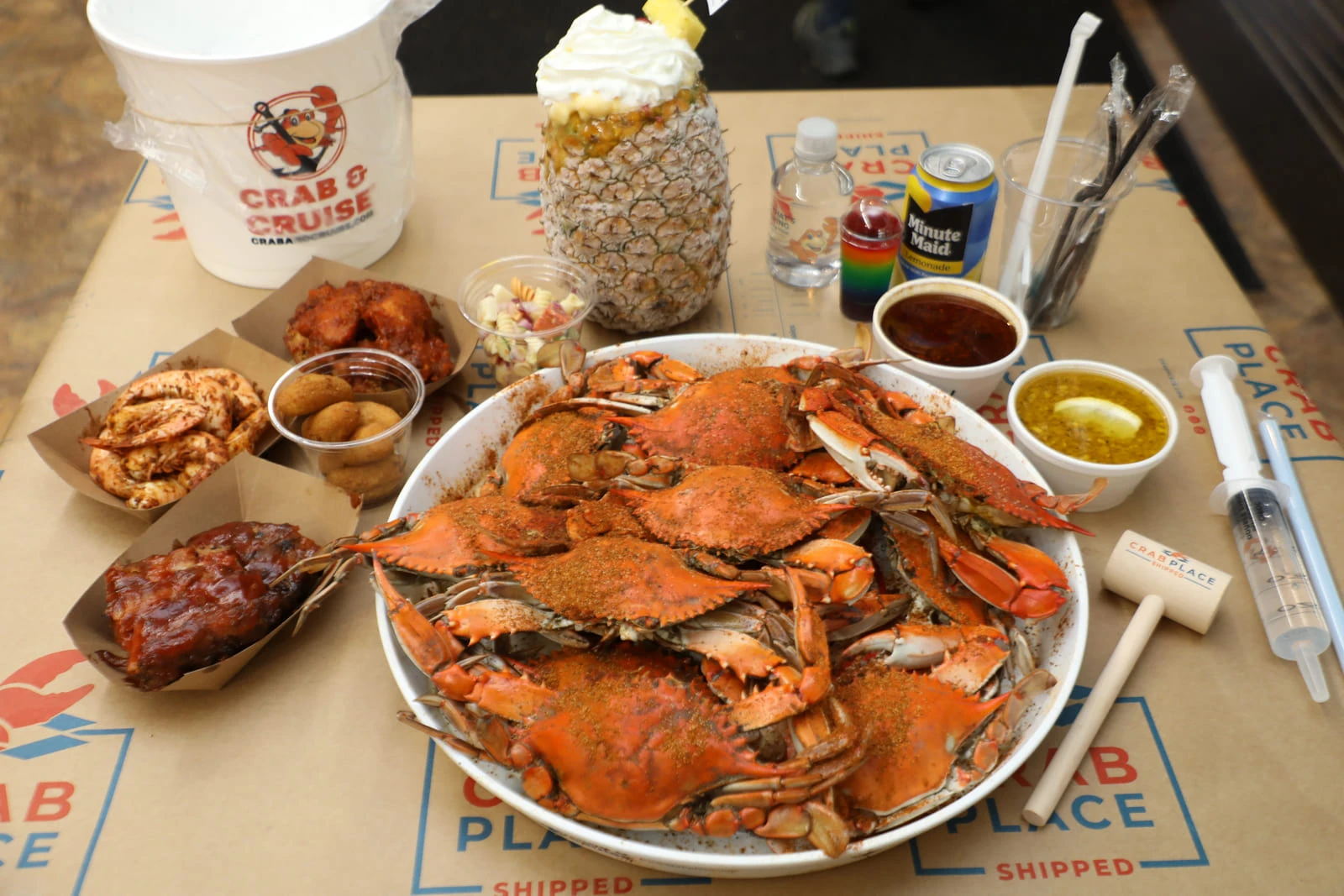 A tray of steamed Maryland blue crabs with sides at a Crab & Cruise event