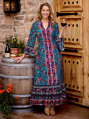 Image of a woman at a winery wearing the bright magenta and blue Allene Maxi Dress