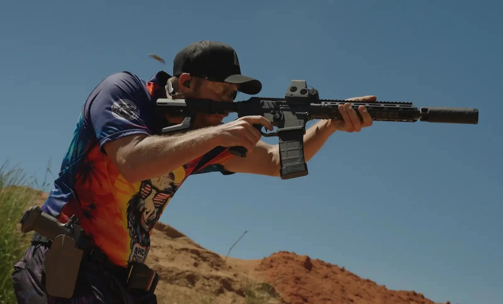 Max Leograndis shooting a suppressed rifle on a desert range