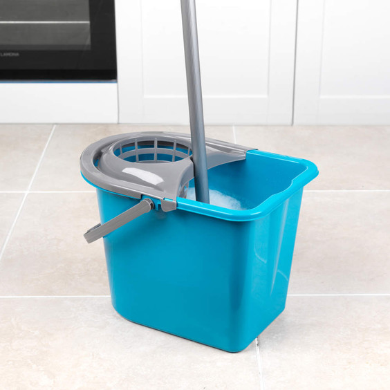 Blue plastic mop bucket with grey wringer and mop, shown on tiled kitchen floor.