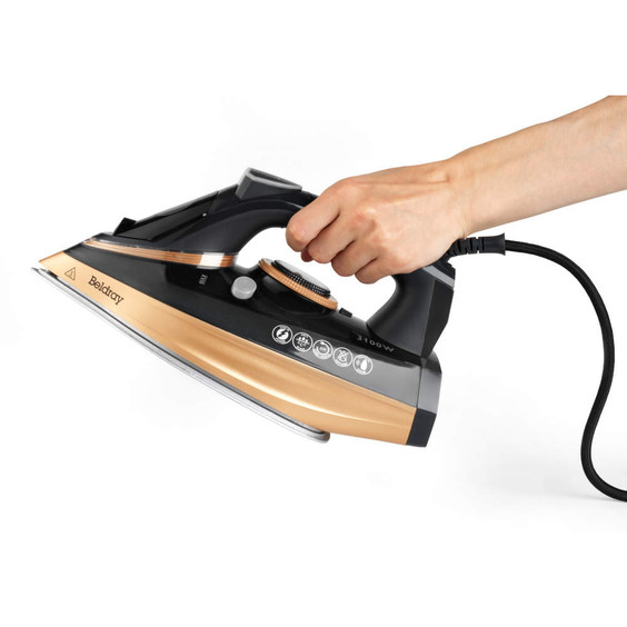 Hand holding black and copper steam iron, Beldray branding visible, shown side-on.