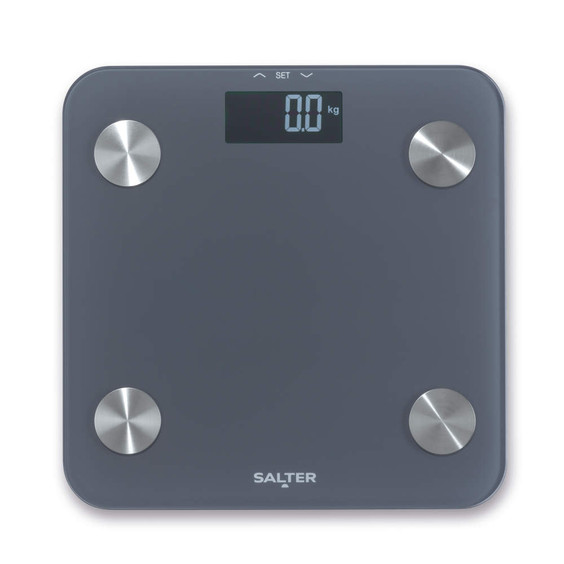 Grey digital bathroom scale with round metal sensors and LCD display, viewed from above