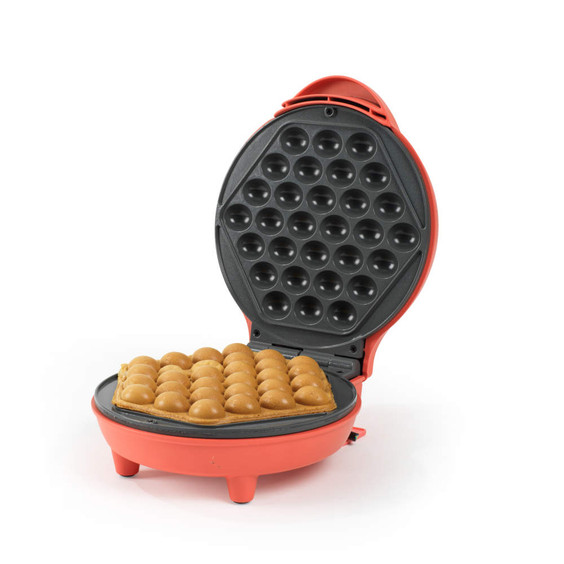 Red bubble waffle maker open with golden waffle inside, shown on a white background