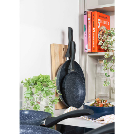 Set of two black non-stick frying pans with ergonomic handles, displayed on a kitchen counter.