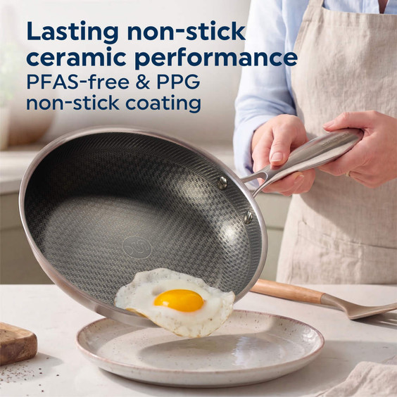 Ceramic non-stick frying pan with fried egg sliding out, PFAS-free coating highlighted