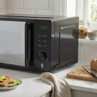 Black microwave oven on kitchen worktop, front view, product listing image